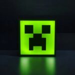 Cube en acrylique lumineux avec motif pixelisé de creeper de Minecraft, éclairé en vert fluo, idéal pour décoration d'intérieur ou comme lampe LED originale.