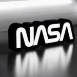 NASA logo en néon LED blanc sur fond noir, créée avec l'impression 3D pour un effet lumineux moderne et personnalisé. Idéal pour la décoration intérieure ou comme pièce unique.
