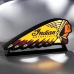 Indian Motorcycle logo en création 3D lumineuse LED, éclairée, sur support noir, conçue avec impression 3D pour décoration vintage, fusion d'art et de technologie.