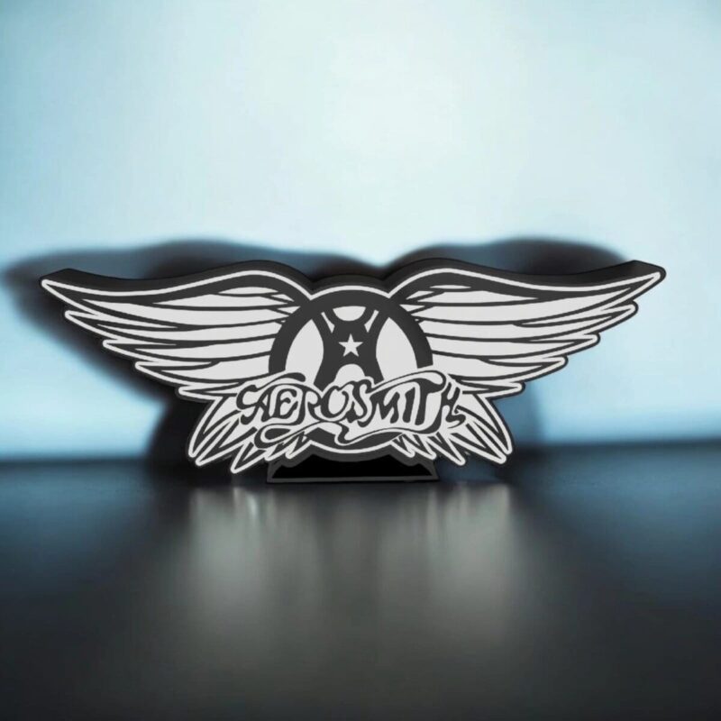 Noueau panneau lumineux 3D avec ailes d'ange et inscription "AEROSMITH" en éclairage LED, design graphique en noir et blanc. Parfait pour décoration musicale ou rock.