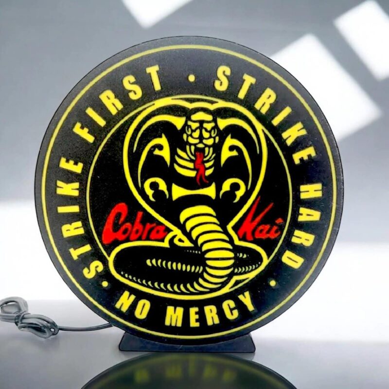 Cadeau patch lumineux en forme de cobra avec texte "First Strike, No Mercy" et logo de serpent, éclairé par LED, idéal pour fan de motos ou collectionneur d’objets customisés.
