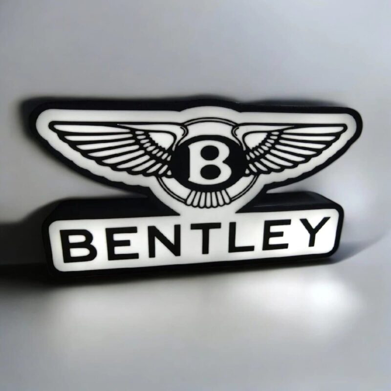 Logo lumineux Bentley en 3D avec texte et ailes noires et blanches, créé par Infinity 3D Print, illuminant élégamment les voitures de luxe avec une finition moderne et design.