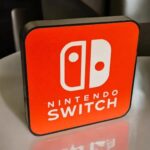 Lampe LED personnalisée avec le logo Nintendo Switch, création lumineuse 3D pour décoration gaming ou collectionnite, éclairage innovant et design moderne.