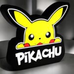 Pikachu en lampe LED 3D illuminée, création lumineuse colorée inspirée de l'univers Pokémon, idéale décoration pour fans, avec texte Pikachu en dessous.