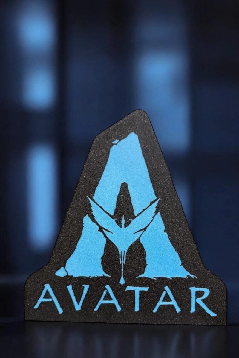 1743957271.jpeg Vitrine d'une lampe LED 3D représentant le logo du film Avatar, conçue par Infinity 3D Print, illuminée en bleu avec un fond sombre.