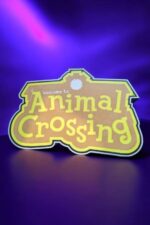 Lampe 3D lumineuse avec texte "Welcome to Animal Crossing" colorée et rétro, éclairée par une lumière LED vive, idéale pour la décoration et l'ambiance chaleureuse.