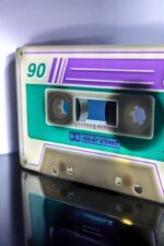 Un cassette audio vintage avec des couleurs néon et effets lumineux, mettant en valeur l'esthétique rétro d'Infinity 3D Print – Créations lumineuses 3D.