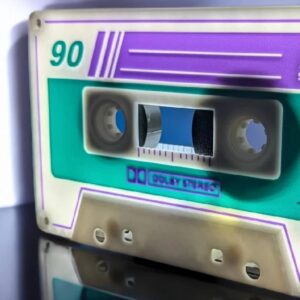 Un cassette audio vintage avec des couleurs néon et effets lumineux, mettant en valeur l'esthétique rétro d'Infinity 3D Print – Créations lumineuses 3D.