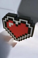 Pixel art cœur LED 3D, création lumineuse inspirée du jeu vidéo rétro, idéale pour décoration ou cadeaux originaux, fabriquée en impression 3D, sur fond blanc, mise en valeur avec éclairage doux.