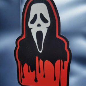 Un sticker 3D personnalisé représentant une figure avec un masque de Scream, fabriqué avec impression 3D, idéal pour la décoration lumineuse et originale.