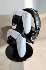 Manette de jeu PlayStation 5 et casque audio en arrière-plan, affichés sur un support de présentation.