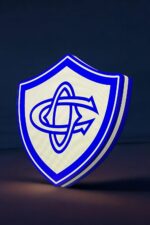 LED logo en 3D, création lumineuse avec éclairage bleu et blanc, figurine de protection ou de branding sur fond sombre.