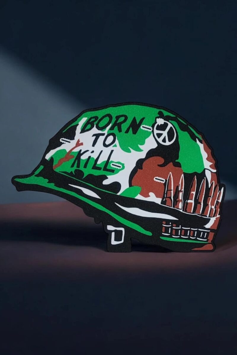Panneau lumineux en forme de casque avec message "BORN TO KILL" et design coloré, éclairé pour une décoration moderne ou une pièce design.