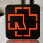 Lampe LED design avec logo orange sur fond noir, création lumineuse moderne et élégante pour décoration d’intérieur.