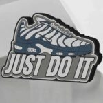 Dessin d’une chaussure Nike Air Max avec le texte “Just Do It” en lettres épaisses, réalisée avec une imprimante 3D lumineuse, illustrant la créativité et l’innovation en impression 3D.