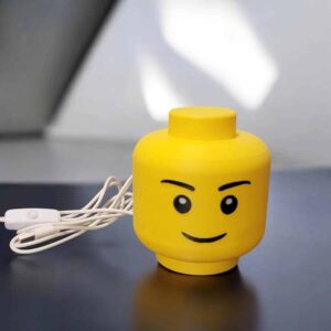 Lego-inspired veilleuse LED jaune avec un visage souriant, idéale pour une touche déco lumineuse.