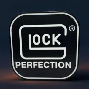 Logo GLOCK lumineux 3D avec inscription "PERFECTION" sur fond noir, idéal pour décoration ou collection.