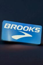 Brooks logo en impression 3D avec éclairage LED bleu, création lumineuse unique pour décoration ou signalétique.