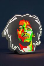 Vignette d'une lampe LED 3D représentant une portrait de style pop art de Bob Marley illuminée avec des couleurs vives, créée par Infinity 3D Print, parfait pour la décoration intérieure moderne.