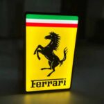 LED lumineux en forme de logo Ferrari avec éclairage blanc sur fond noir, création artistique 3D pour décoration ou collection.